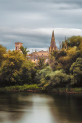 river and the wind in the trees with a church on the background