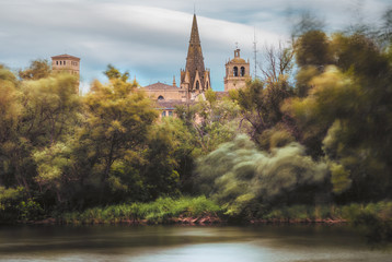 river and the wind in the trees with a church on the background