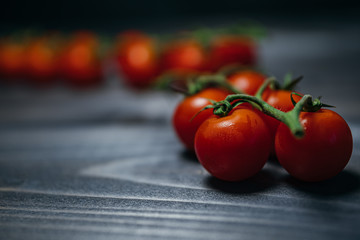Fresh red cherry tomatoes on a black background. Top view with copy space.