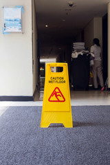 Sign showing warning of caution wet floor, cleaner on the background