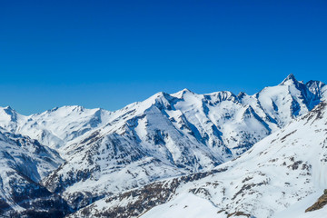 Plakat A beautiful and serene landscape of mountains covered with snow. Thick snow covers the slopes. Clear weather. Sharp slopes of the mountains covered with snow, with partially visible rocks.