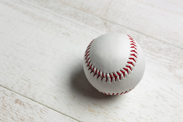White baseball ball stitched with red thick.