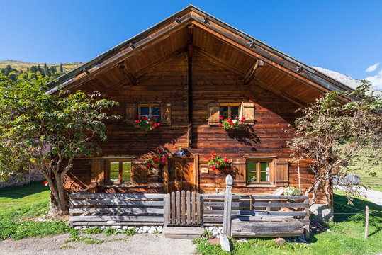 Holzh&uuml;tte mit Geranien in Blumenk&auml;sten auf der Eng-Alm auf dem gro&szlig;en Ahornboden im Sonnenlicht, Tirol, &Ouml;sterreich