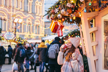 Fototapeta na wymiar Girl walking on Christmas Market on Red Square in Moscow