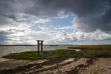 Angry dark clouds gathering over Harty Ferry and The Swale on the Isle of Sheppy, Kent, England