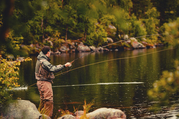 Coil of fly fishing rope, man hands holding rod - obrazy, fototapety, plakaty