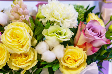 Obraz na płótnie Canvas Close-up photo of Yellow and Lilac Bouquet of Roses, Cotton Flowers, Lupine, Eustoma in Provence Style. Lovely Floral Background. Selective Focus