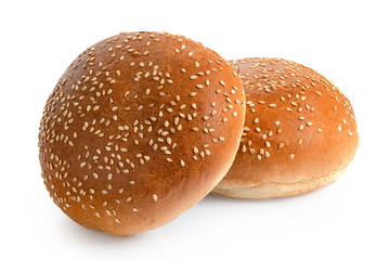 Two sesame seed hamburger buns isolated on white.