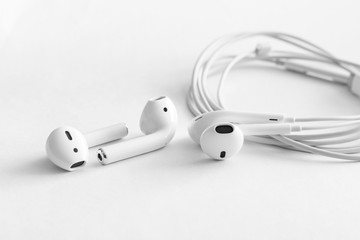 White headphones wireless bluetooth comparison with wired earphones, copy space