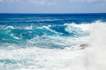 Waves and foam on surface of blue turquoise ocean water after storm, natural background