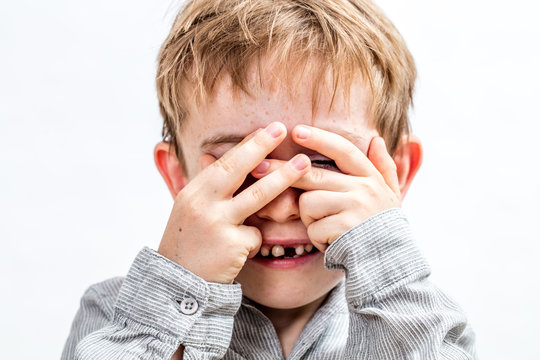 Smiling Child With Tooth Missing Hiding Face To Play Peekaboo