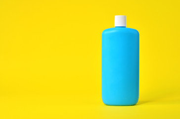 Empty blue plastic bottle on a yellow background