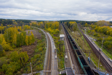 Fototapeta na wymiar A top down view of railway tracks running through woodland and trees.