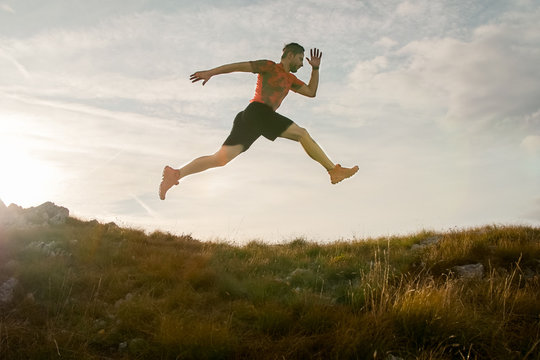 Trail running man jumping in the sky