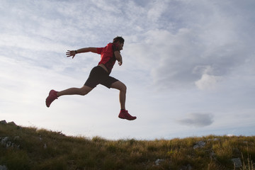 Fototapeta na wymiar Trail running man jumping in the sky