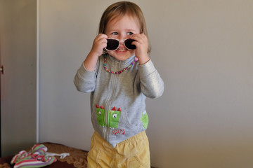 Portrait of a smiling girl playing with glasses.