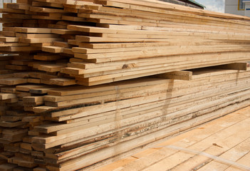 Lumber warehouse. Long wood planks stacked outdoors