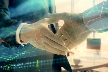 Multi exposure of financial graph on office background with two businessmen handshake. Concept of success in business