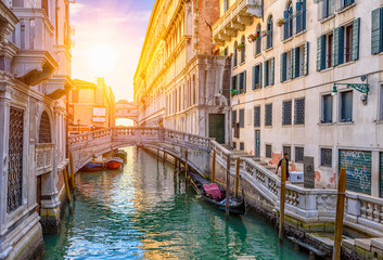 Obraz na płótnie Canvas Narrow canal with gondola and bridge in Venice, Italy. Architecture and landmark of Venice. Cozy cityscape of Venice.