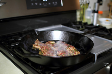 Korean style BBQ short ribs, known as Kalbi, on a cast iron skillet in a home kitchen.