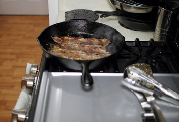 Korean style BBQ short ribs, known as Kalbi, on a cast iron skillet in a home kitchen.
