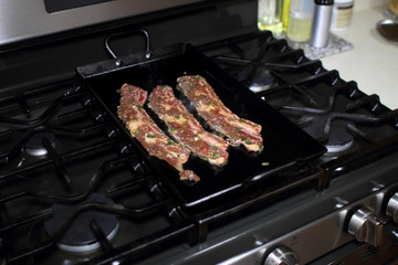 Korean style BBQ short ribs, known as Kalbi, on a carbon steel griddle in a home kitchen.
