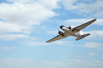 Fototapeta na wymiar airplane with propeller flying in blue sky 