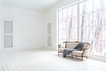 A spacious bright living room with a stylish modern design with elements of antique decor and beautiful chic furniture