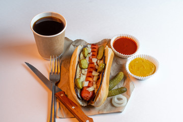 Complex lunch - hot dog, mustard and coffee with cutlery. Street food. Fast food. BBQ. Grill