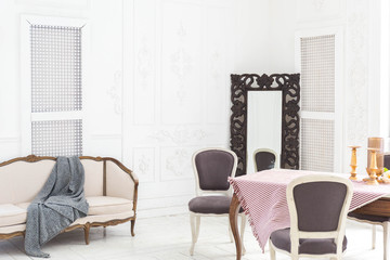 A spacious bright living room with a stylish modern design with elements of antique decor and beautiful chic furniture