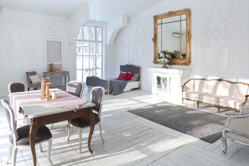 A spacious bright living room with a stylish modern design with elements of antique decor and beautiful chic furniture