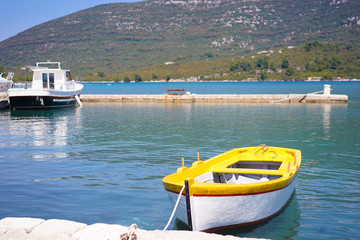 Obraz premium Row boat. A yellow row boat is parking in the lake during summer.