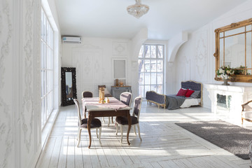 A spacious bright living room with a stylish modern design with elements of antique decor and beautiful chic furniture