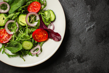 Healthy salad, leaves mix salad (mix micro greens, cucumber, tomato, onion, other ingredients). food background. copy space