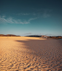 Empty giant sand dunes and beach with shadows and deep blue sky and sand texture. Praia da Bordeira at the Algarve Coast in Portugal, Atlantic Ocean
