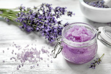 Obraz na płótnie Canvas Natural sugar scrub and lavender flowers on white wooden table, space for text. Cosmetic product