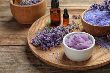 Plate with natural cosmetic products and lavender flowers on wooden table
