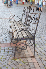 Wooden bench on the city street, Forged elements