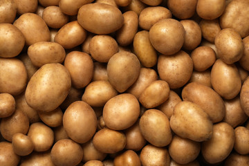 Raw fresh organic potatoes as background, top view
