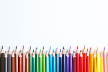 Composition with color pencils on white background, flat lay. Space for text