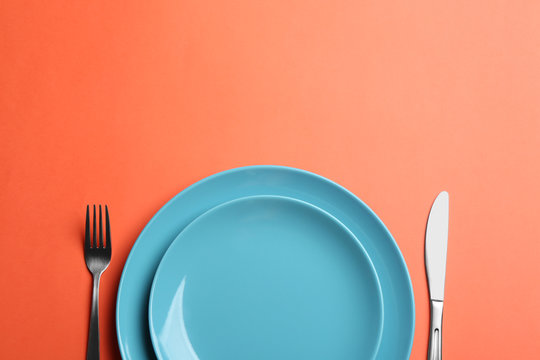 Elegant table setting on orange background, flat lay. Space for text
