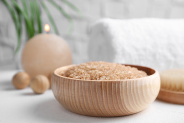 Fototapeta na wymiar Salt for spa scrubbing procedure in wooden bowl on white table