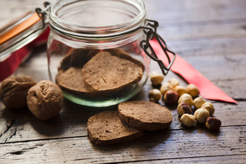 Homemade rustic wholegrain cookies on a wooden table with jar and decoration