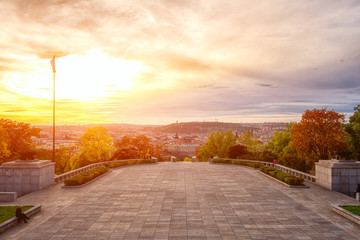 Sunset view of Prague from Vitkov hill with autumn park, scenic sunny cytiscape, Zizkov district,...