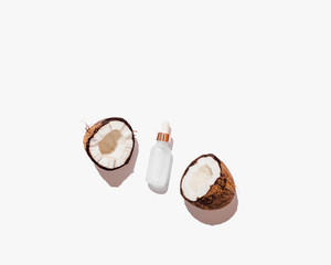 Cosmetic coconut oil between two halves of fresh cracked coconut