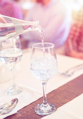 man pouring water into the glass