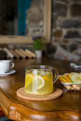 Hot lemon, ginger and apple tea with spices in a glass teapot. Health fresh fruit drink. Enjoying hot beverage in cold winter evening. Selective focus