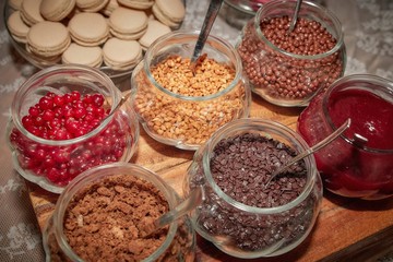 Jars with cereal chips, chocolate, cookies and jam.