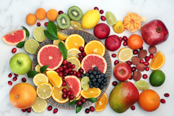 Large healthy fresh fruit collection on a round plate and marble background. Super food very high in antioxidants, vitamins, dietary fibre and anthocaynins. Top view.