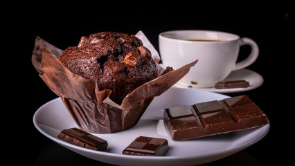 Chocolate muffin, Chocolate and cup of black coffee on the table.